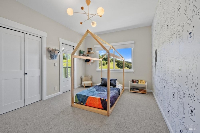 bedroom featuring baseboards, access to outside, carpet flooring, and an inviting chandelier