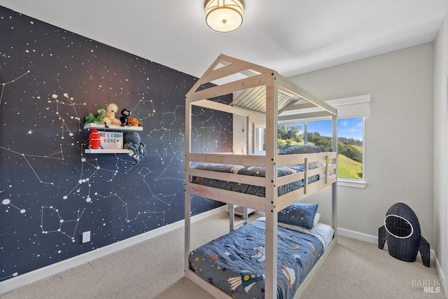 bedroom featuring baseboards, carpet flooring, an accent wall, and wallpapered walls