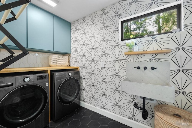 laundry area with independent washer and dryer, dark tile patterned floors, and cabinet space