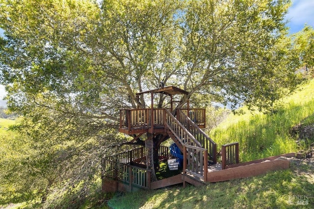 view of play area featuring stairway and a wooden deck