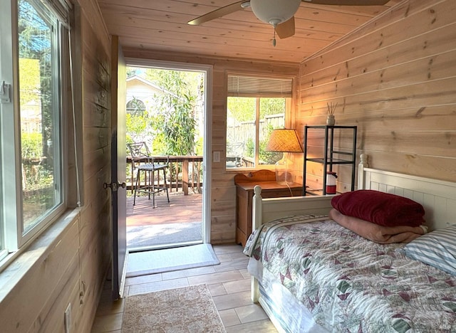 bedroom with lofted ceiling, wooden walls, wooden ceiling, and access to outside