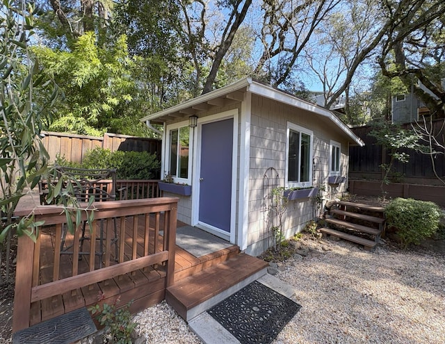 view of outbuilding with fence and an outbuilding