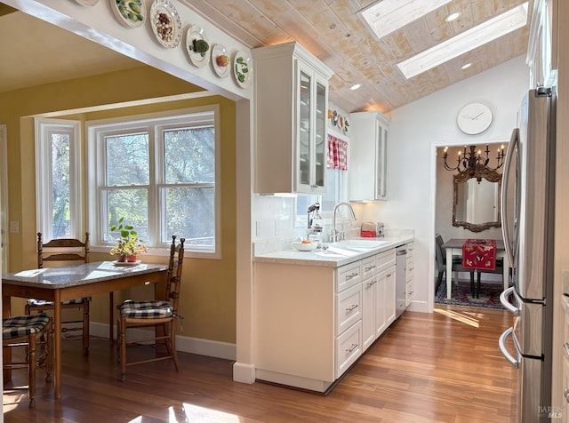 kitchen featuring a sink, wood ceiling, light wood finished floors, white cabinets, and appliances with stainless steel finishes