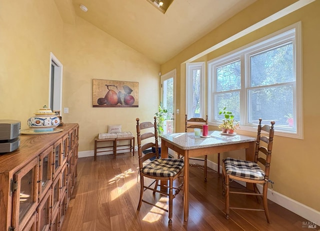 dining area featuring lofted ceiling, baseboards, and dark wood finished floors