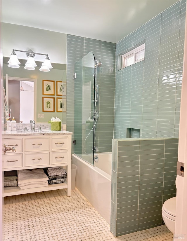 bathroom with tiled shower / bath combo, vanity, and toilet