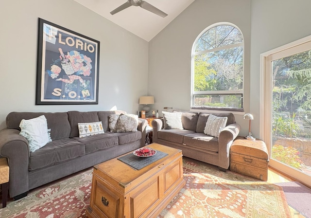 living room with a wealth of natural light, ceiling fan, and high vaulted ceiling