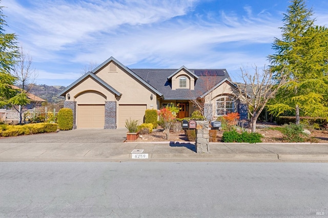 view of front of property with stucco siding, a garage, and concrete driveway