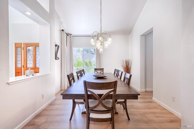 dining room featuring a chandelier, light wood finished floors, and baseboards