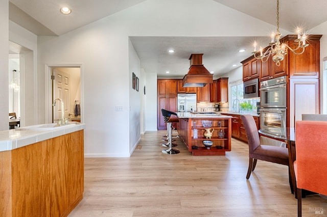 kitchen featuring light wood-style floors, open shelves, a chandelier, lofted ceiling, and built in appliances