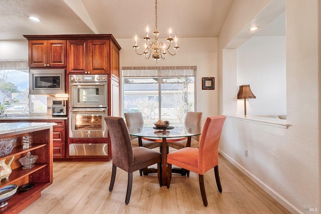 dining room featuring light wood finished floors, an inviting chandelier, and a wealth of natural light