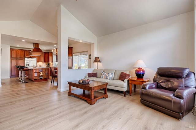 living room with high vaulted ceiling and light wood-style floors