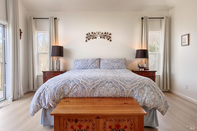 bedroom with baseboards, access to outside, and wood finished floors