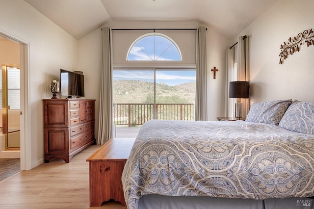 bedroom with light wood-style floors, access to exterior, vaulted ceiling, and connected bathroom