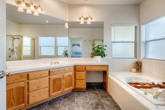 bathroom with a stall shower, a garden tub, and vanity