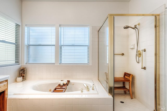 bathroom featuring a shower stall, vanity, a tub with jets, and plenty of natural light