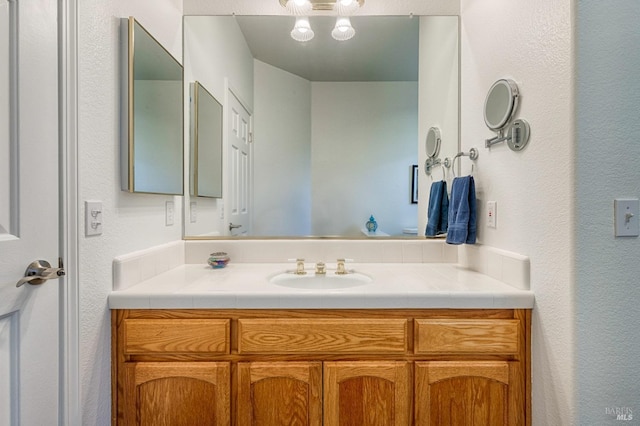 bathroom featuring a textured wall and vanity