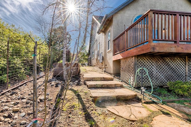 exterior space with stucco siding and a deck