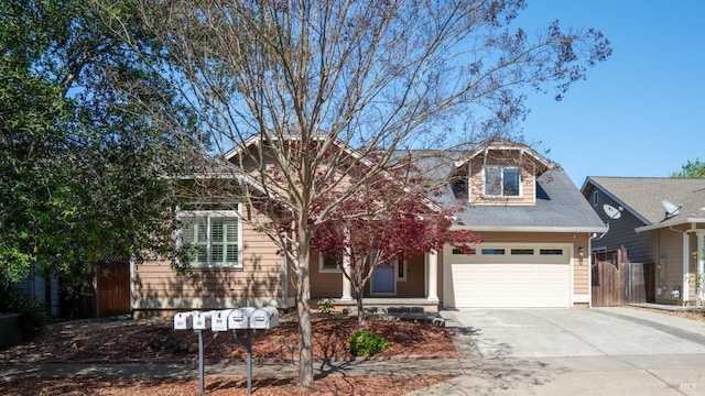 view of front of house featuring a garage, fence, and driveway