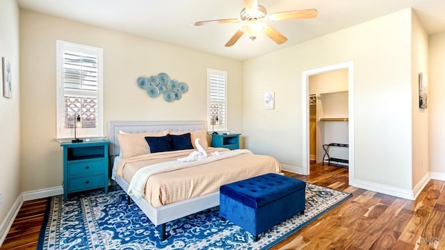 bedroom featuring baseboards, wood finished floors, and multiple windows