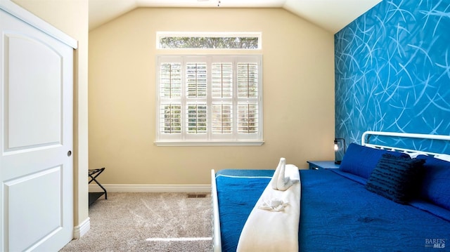 unfurnished bedroom with baseboards, carpet flooring, lofted ceiling, and visible vents