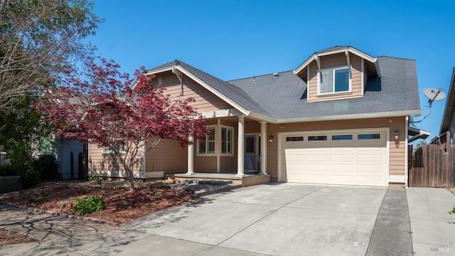 craftsman-style house featuring roof with shingles, fence, and driveway