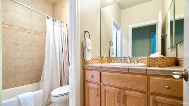 bathroom featuring vanity, shower / tub combo, and toilet
