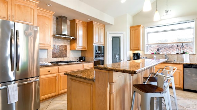 kitchen with decorative backsplash, a kitchen island, wall chimney range hood, dark stone countertops, and appliances with stainless steel finishes