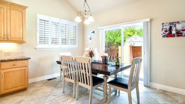 dining room with visible vents, lofted ceiling, light tile patterned flooring, baseboards, and a chandelier