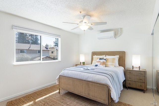 bedroom featuring baseboards, an AC wall unit, a textured ceiling, a ceiling fan, and carpet
