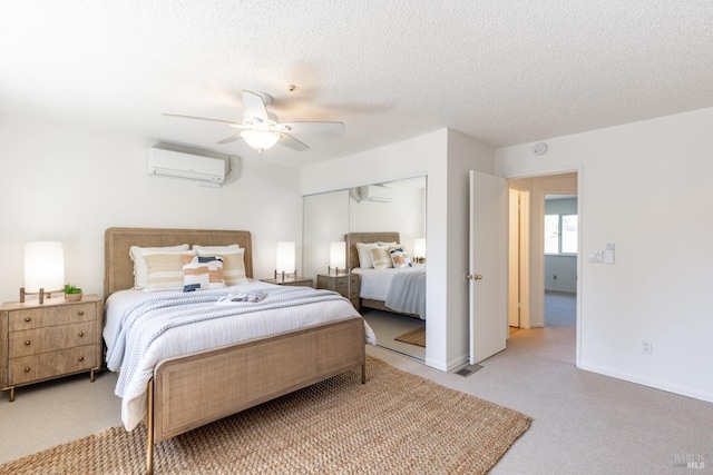 carpeted bedroom featuring baseboards, an AC wall unit, a textured ceiling, and a ceiling fan