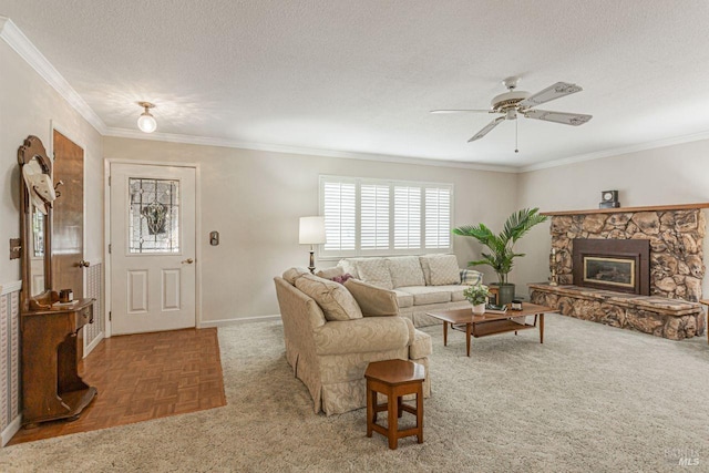 living room featuring baseboards, a stone fireplace, ornamental molding, a textured ceiling, and a ceiling fan