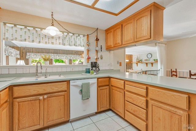 kitchen with a peninsula, light tile patterned flooring, light countertops, dishwasher, and a sink