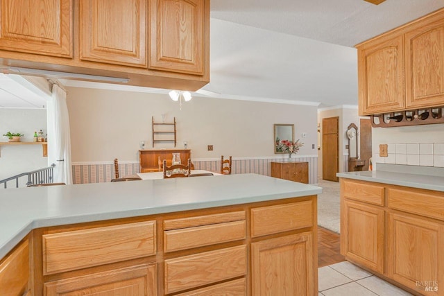 kitchen with light tile patterned floors, light countertops, and crown molding