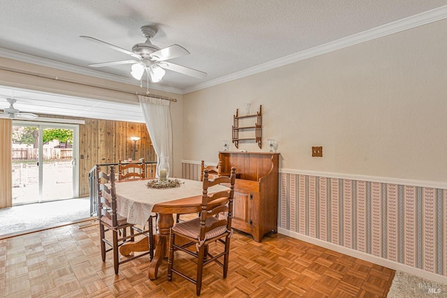 dining room featuring baseboards, a textured ceiling, ornamental molding, and ceiling fan