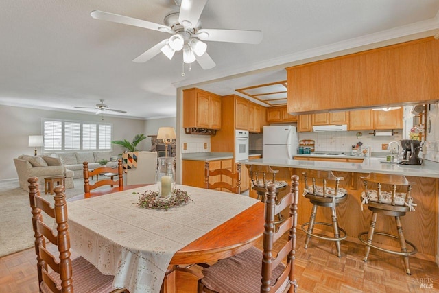 dining room with a ceiling fan and ornamental molding