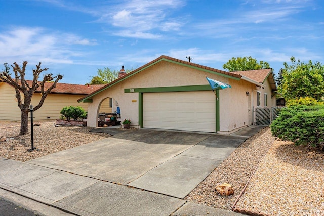 ranch-style house featuring concrete driveway, stucco siding, fence, and an attached garage