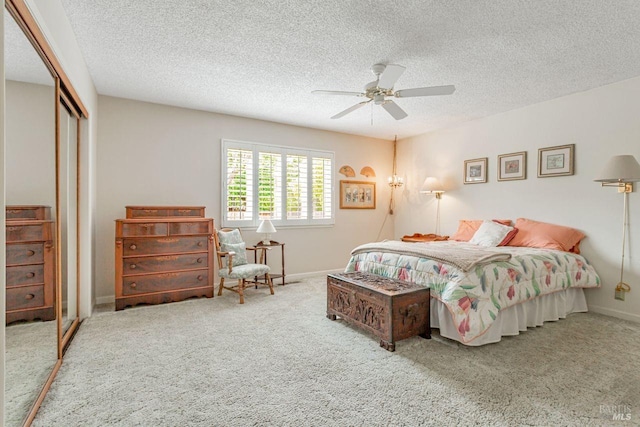 bedroom featuring baseboards, a closet, a textured ceiling, a ceiling fan, and carpet floors