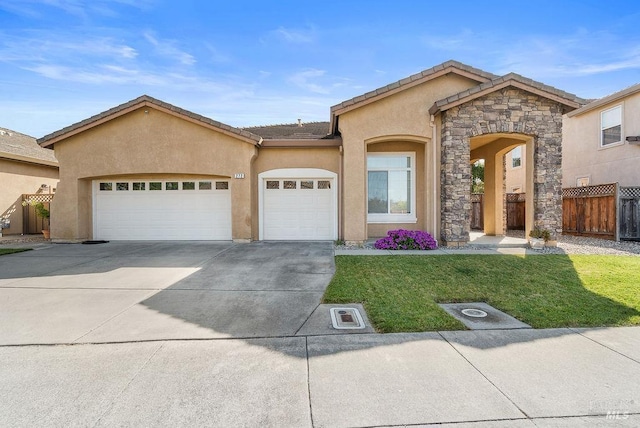 view of front of property featuring stucco siding, fence, a front lawn, an attached garage, and concrete driveway