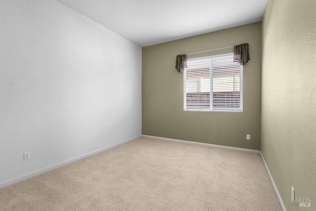 unfurnished room with carpet flooring and baseboards