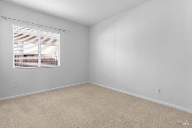 unfurnished room with baseboards and carpet floors