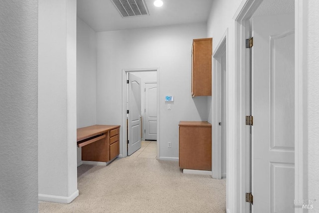 corridor with light carpet, visible vents, and baseboards