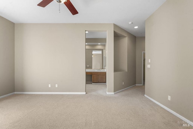 spare room with ceiling fan, light colored carpet, recessed lighting, a sink, and baseboards