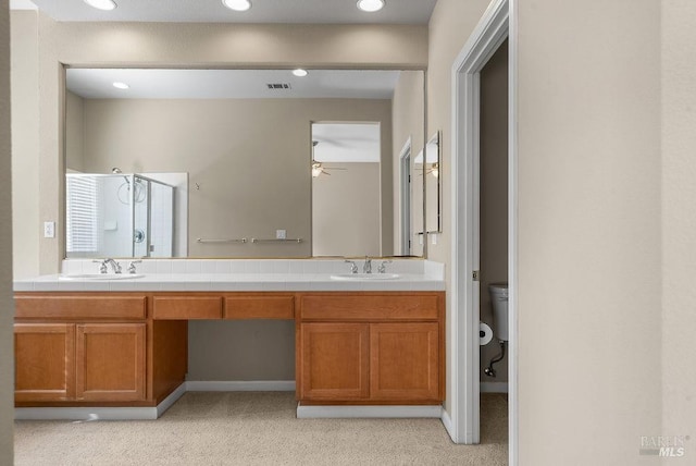 bathroom with a sink, ceiling fan, double vanity, and a stall shower