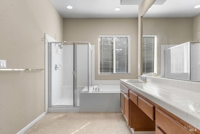 bathroom featuring vanity, baseboards, a garden tub, and a stall shower