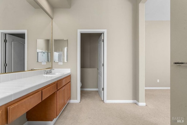 bathroom featuring vanity, baseboards, and toilet