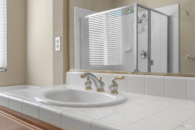 bathroom featuring a shower stall and a sink