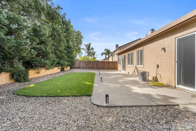 view of yard featuring a patio area, a fenced backyard, and central AC