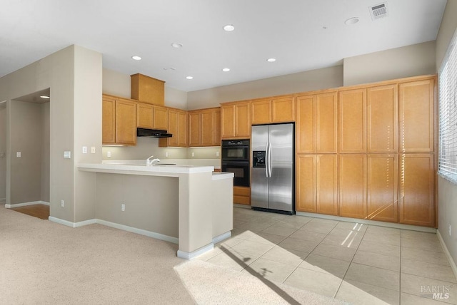kitchen featuring stainless steel fridge with ice dispenser, a peninsula, under cabinet range hood, dobule oven black, and visible vents