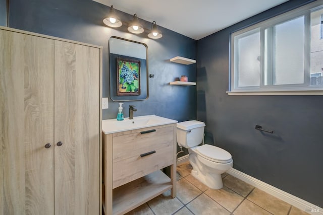 bathroom with toilet, tile patterned flooring, baseboards, and vanity