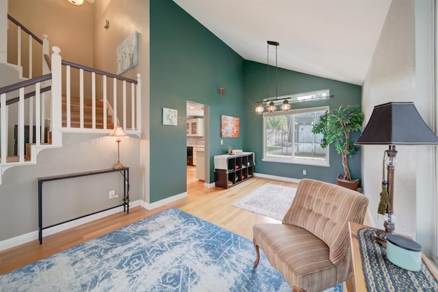 living area featuring wood finished floors, baseboards, and stairway